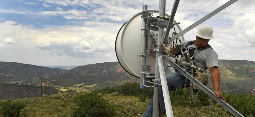 A tower technician for Advanced Wireless Solutions, works to make some repairs on the dish on the Pollard cell tower high off the ground in rural Rio Blanco County on July 12, 2017 near Meeker, Colorado.
