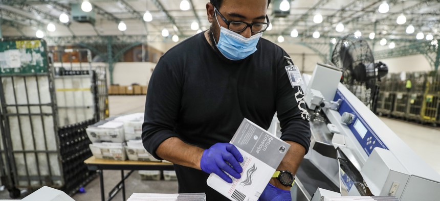 Industry, CA, Thursday, June 16, 2022 - LA County poll worker Chris Torres mans a machine that automatically opens mail in ballots as they are processed inside a converted Frys Electoronics store.